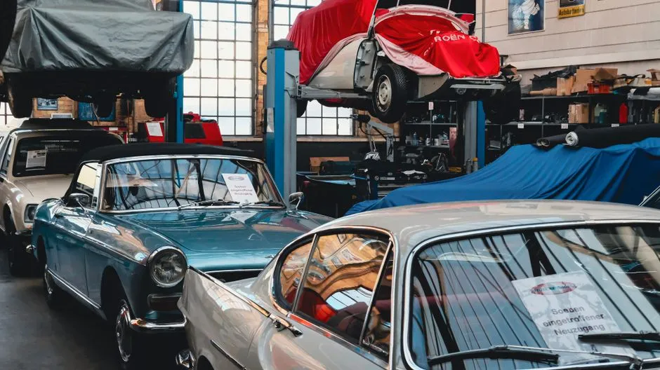 Vintage cars parked inside an indoor garage storage bay
